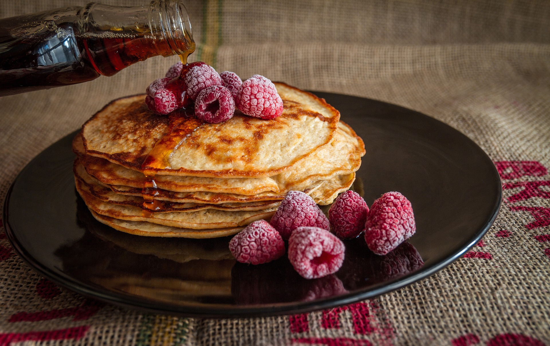 Maple syrup poured over pancakes